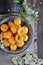 On a wooden table on a platter of fresh apricots with bones, decorated with flowers. View from above