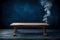 Wooden table that is for product montages. background of smokey dark blue