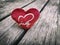 A wooden table with red hearts placed, a festive idea for Valentine`s Day