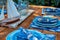 wooden table with a sailboat model, blue plates, and fishpatterned napkins
