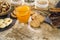 Wooden table set for a sweet vegan breakfast with orange juice, sliced banana, mixed dried fruit, vegan biscuits, slices of bread