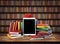 Wooden table with a stack of colored books, tablet, pencil, school supplies, apple. Education concept, back to school. Blurred