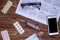 Wooden table with syringe, pills, glasses, phone, object set