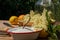 On the wooden table there is an enamel bowl with sugar, a vanilla pod and a basket with fish harvested elderberry blossoms