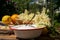 On the wooden table there is an enamel bowl with sugar, a vanilla pod and a basket with fish harvested elderberry blossoms