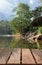 Wooden table top on blur stream water and forest natural background in private resort.For montage product display or design key