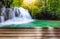 Wooden table top on fantastic waterfall in tropical forest