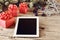 On the wooden table white tablet with Christmas presents closeup