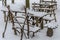 Wooden tables and chairs - furniture for a picnic handmade, stand among snow-covered woods strewn with snow