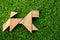 Wooden tangram puzzle in dog shape on artificial green grass background