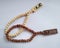 Wooden tasbih a tool for calculating wirid. Moslem prayer. Brown and cream tasbih beads on white background.
