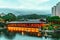 Wooden tea restaurant by pond in Nan Lian Garden at Diamond Hill in Hong Kong. Scenic twilight cityscape