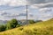 A wooden telephone post with on a hill side.