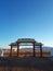 Wooden temple gate with white fence yellow roof clear blue sky