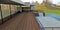 Wooden terrace of flat roof high tech house. Swimming pool and hilly field. 3d render.