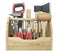 A wooden toolbox containing with ax, chisel, pliers, mallet, hammer, screwdriver, wrench, saw and wire cutters