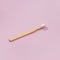 Wooden toothbrushe with shadows on a pink background