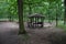 Wooden tourist gazebo in the oak forest. tourists have a place to hide when it rains. a snack under the roof on a bench is more co