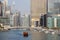 Wooden touristic ship sails on the bay against the background of modern buildings in the district of Dubai Marina