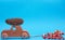 Wooden toy car carries on top a pine cone on a blue background