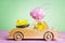 Wooden toy car with Easter egg on the roof and chick driver.