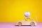 Wooden toy car with Easter egg on the roof and chick driver on y