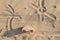 Wooden toy car on sandy beach background with painted sun and palm. Eco-friendly travel, reduce carbon footprints