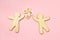 Wooden toy people and fresh summer chamomile flowers on pastel pink background, love, friendship, dating symbol, top view, flat la