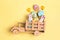 Wooden toy truck with Easter homemade gingerbread cookies  in the back on yellow background. Funny Easter decoration