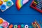 Wooden toys, cubes, brushes on classic blue background. Back to school background. Close up. Top view, copy space. Education