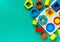 Wooden toys, shape sorter board on green background. Back to school. Close up. Top view, copy space. Education