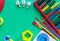 Wooden toys, shape sorter board on green background. Back to school. Close up. Top view, copy space. Education