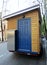 Wooden trailer with blue door.