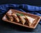 A wooden tray of fried samosas