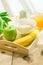 Wooden Tray with Healthy Breakfast Ingredients on Table. Oats in Bowl Nut Milk in Pitcher Orange Juice Banana Green Apple