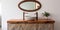 Wooden vanity with stone round vessel sink and mirror in frame on white wall. Interior design