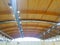 Wooden vaulted ceiling of the hall, with reflectors and air conditioning