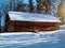 Wooden vintage country house in mountains forest covered snow on nature landscape. Active rest. Snowy winter holidays