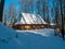 Wooden vintage country house in mountains forest covered snow on nature landscape. Active rest. Snowy winter holidays