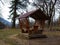 Wooden vintage empty gazebo for rest in the forest on the background of mountains