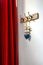 Wooden vintage style hanger with decorative blue heart and red curtain. Hooks on a wall at an entrance to home