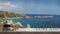 Wooden vintage table shelf with pebble balance and 3d letters making the word feng shui over blurred sea panorama, beach and grani