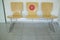 Wooden waiting chairs with social distancing sticker