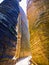 Wooden walking path in deep erosion canyon, surrounded by tall majestic sandstone rock walls, nature tourism destination -