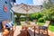 Wooden walkout deck in the backyard garden of blue siding house.