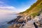 Wooden walkway bridge seashore with mountain landscape in sunrise