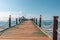wooden walkway leads across the blue sea in fine weather