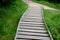 Wooden walkway in a nature reserve in a spruce forest in the mountains over a waterlogged peat bog, gray solid wood across 1m wide