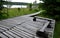 Wooden walkway in a nature reserve in a spruce forest in the mountains through a waterlogged peat bog, gray solid wood leads to a