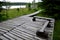 Wooden walkway in a nature reserve in a spruce forest in the mountains through a waterlogged peat bog, gray solid wood leads to